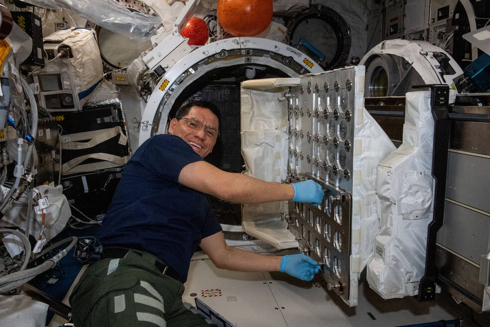 NASA astronaut Frank Rubio works to install the NanoRacks CubeSat Deployer inside the Kibo laboratory module's airlock.