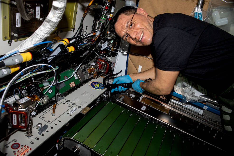 NASA astronaut Frank Rubio performs maintenance on the International Space Station's treadmill located in the Tranquility module.