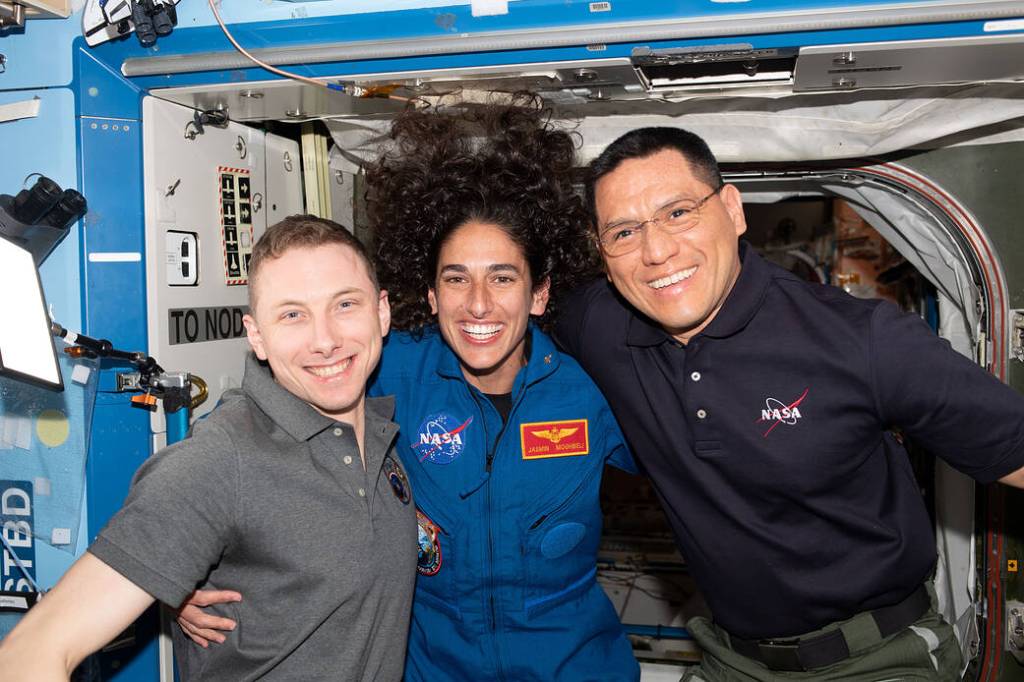 Three Expedition 69 flight engineers pose for a portrait