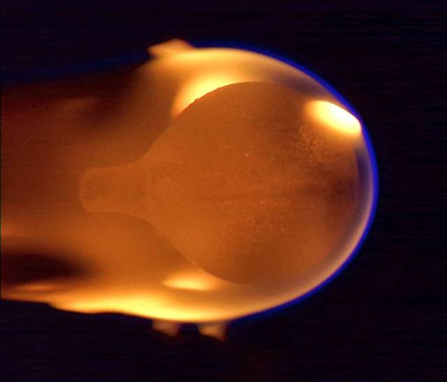 A 4-cm diameter sphere of acrylic burns in microgravity. The orange flame appears near the end of the burn, having engulfed the entire fuel bulb after growing from a small ignition point on the right side.