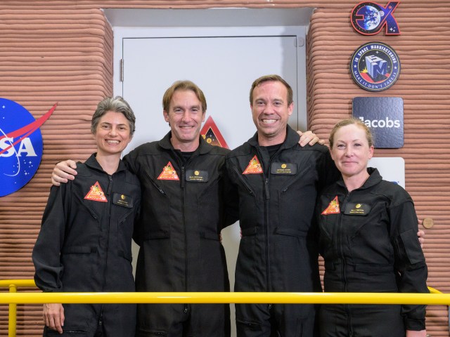 The CHAPEA Mission 1 stands in front of the simulated Mars habitat they will spend one year living and working in. From left is Anca Selariu, science officer; Ross Brockwell, flight engineer; Nathan Jones, medical officer; and Kelly Haston, commander.