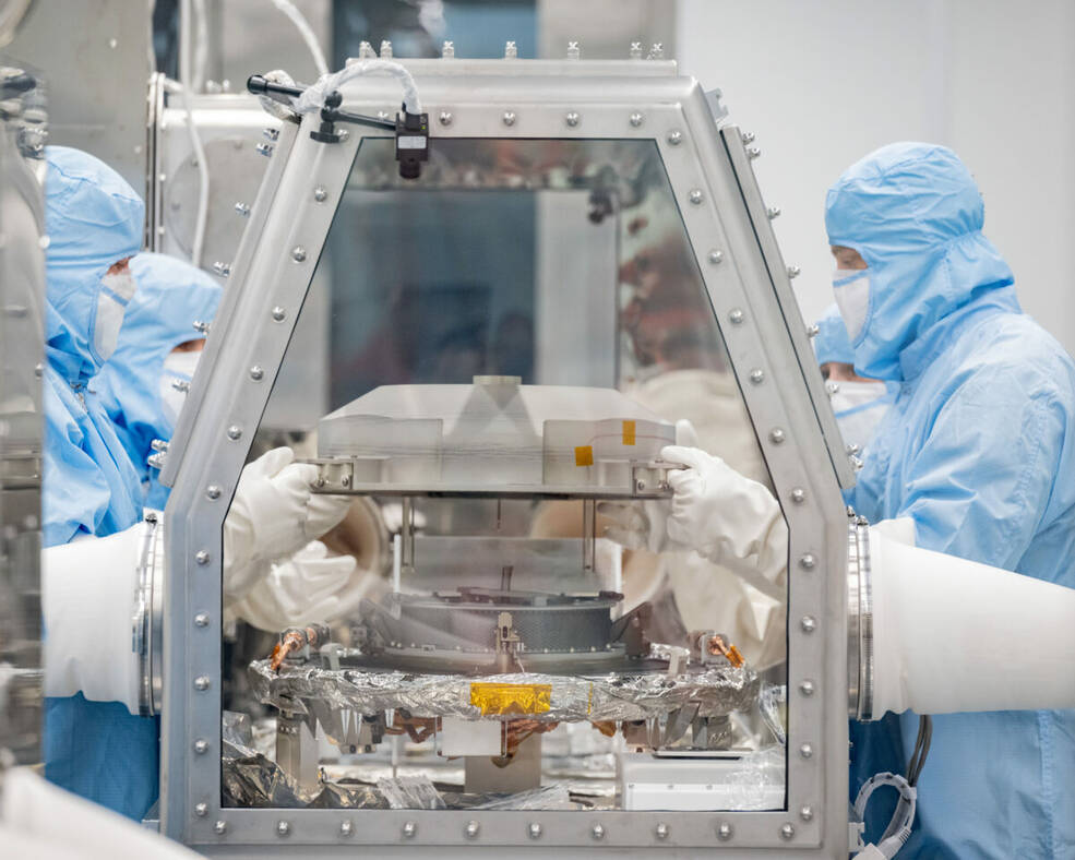 Lockheed Martin recovery specialists remove the lid of the sample return canister at NASAs Johnson Space Center on Sept. 26.