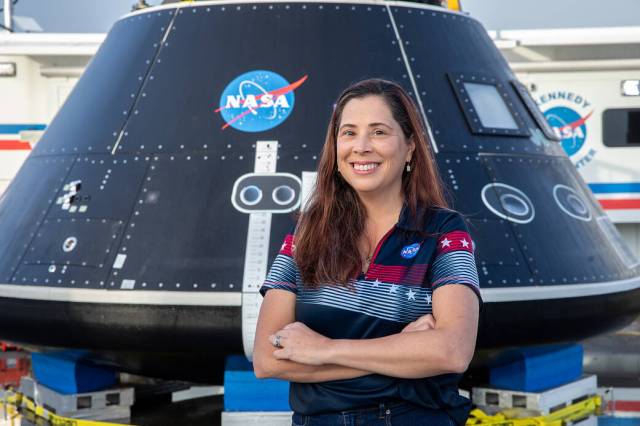 Liliana Villarreal, Artemis landing and recovery director with Exploration Ground Systems (EGS), stands in front of the Crew Module Test Article (CMTA) at the turn basin in the Launch Complex 39 area at NASA’s Kennedy Space Center.