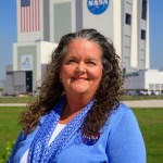 A portrait of Kennedy Space Center's Robyn Mitchell with the Vehicle Assembly Building in the background.
