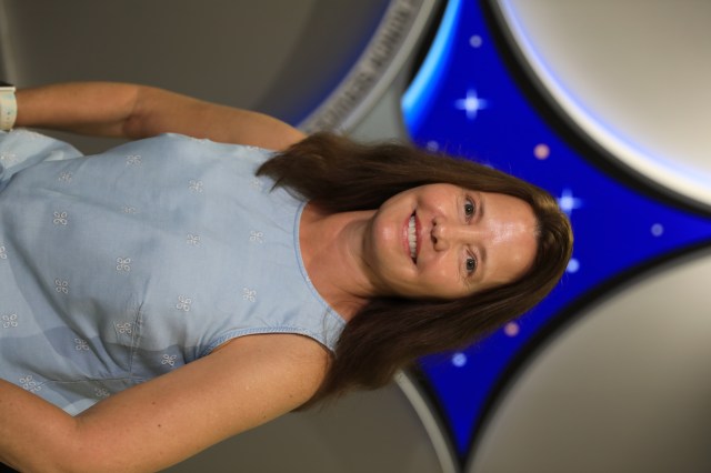 A portrait of Kennedy Space Center's Laura Ulrich with the Launch Services Program insignia in the background.