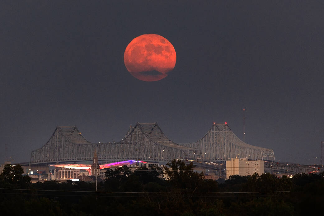 A Super Blue Moon rises above the Mississippi River and the Crescent City Connection Bridge in New Orleans, Aug. 30.