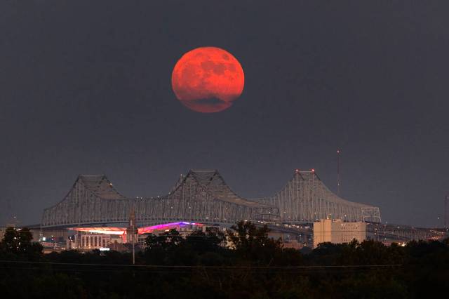 A Super Blue Moon rises above the Mississippi River and the Crescent City Connection Bridge in New Orleans, Aug. 30. The full moon is “super” because it’s slightly closer to Earth and “blue” because it’s the second full moon in a month. About 25% of all full moons are supermoons, but only 3% of full moons are blue moons. The next super blue moons will occur in a pair in January and March 2037. New Orleans is home to NASA’s Michoud Assembly Facility, where stages for NASA’s SLS (Space Launch System) rocket and structures for Orion spacecraft are produced for the Artemis missions.
