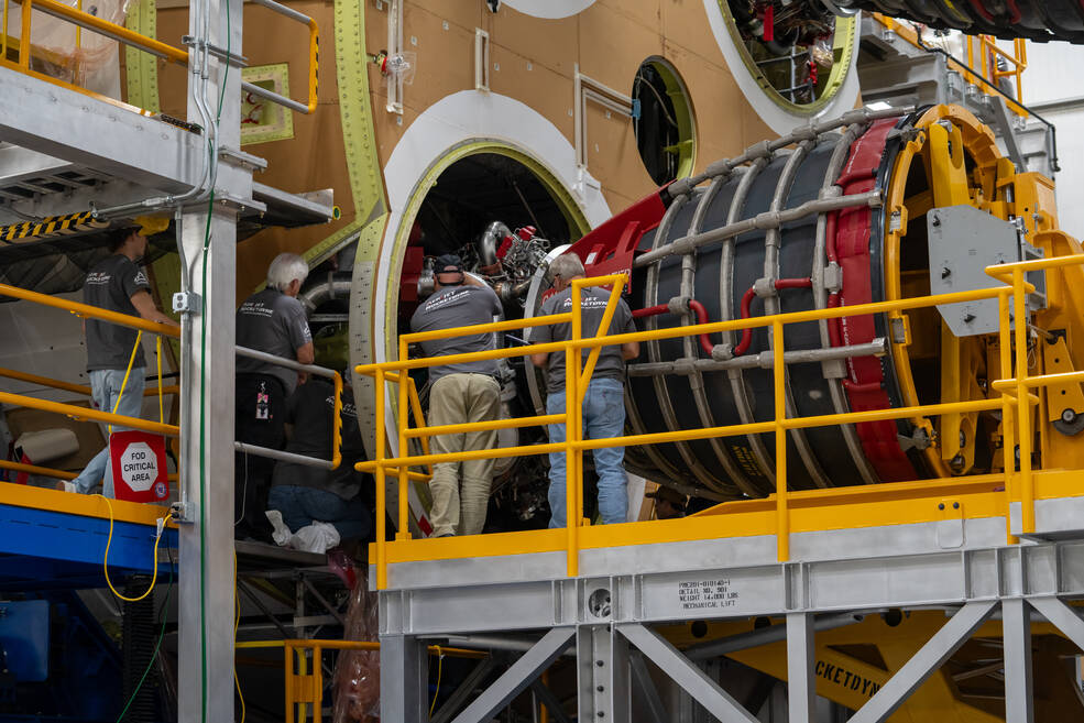 Technicians install the third RS-25 engine to the core stage for Artemis II on Sept. 19.