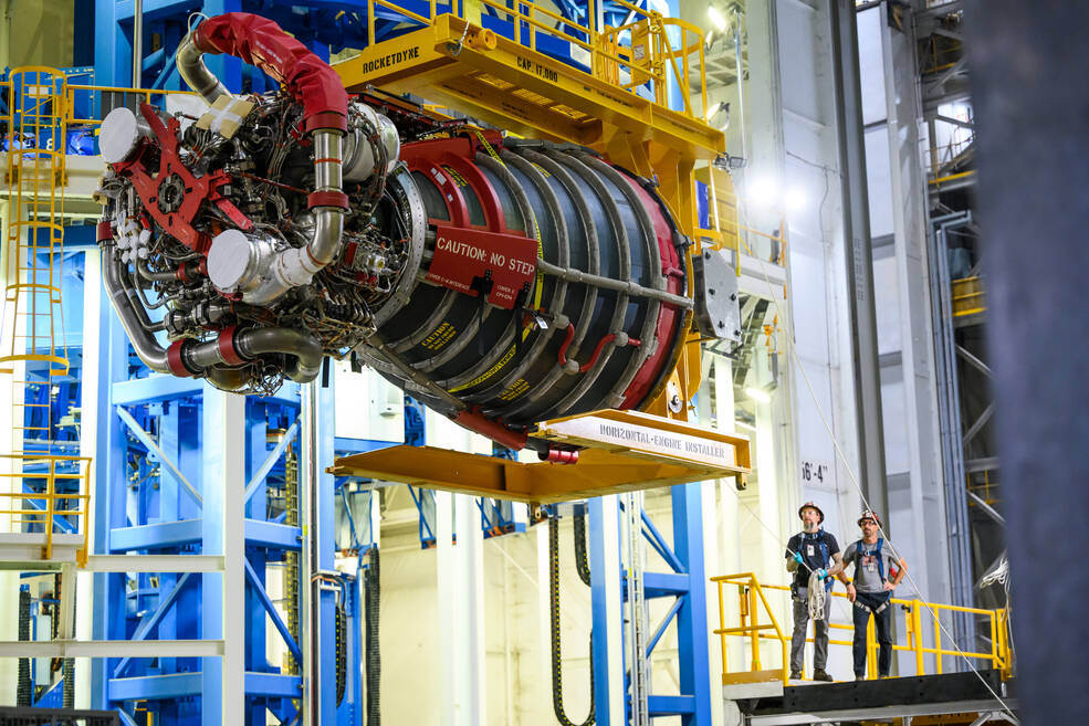 Technicians wait to install the fourth RS-25 engine as it moves into place Sept. 20 at Michoud.