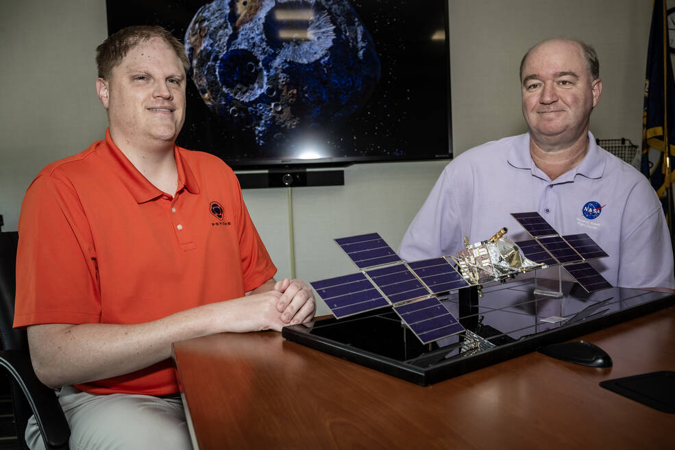 Brad Zavodsky, left, Psyche mission manager in Marshalls Planetary Missions Program Office, and Joel Robinson, Deep Space Optical Communications mission manager at Marshall, ponder a scale model of the Psyche spacecraft.