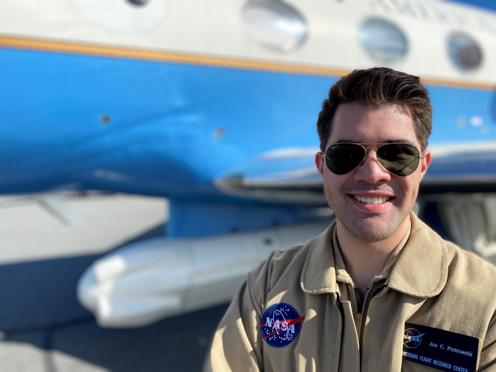 Joe Piotrowski, Jr. smiles in front of NASA Armstrongs Airborne Science aircraft.