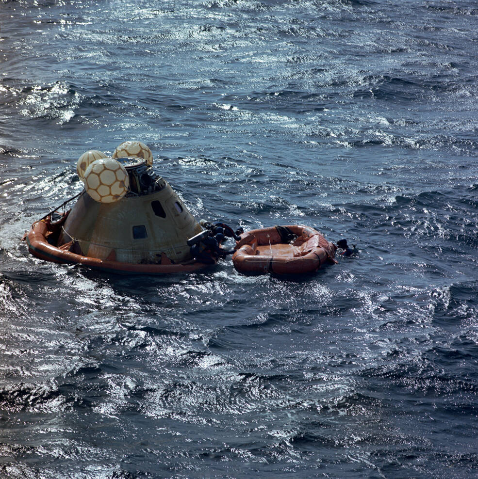 U.S. Navy divers attach a flotation collar to the Skylab 3 Command Module (CM)