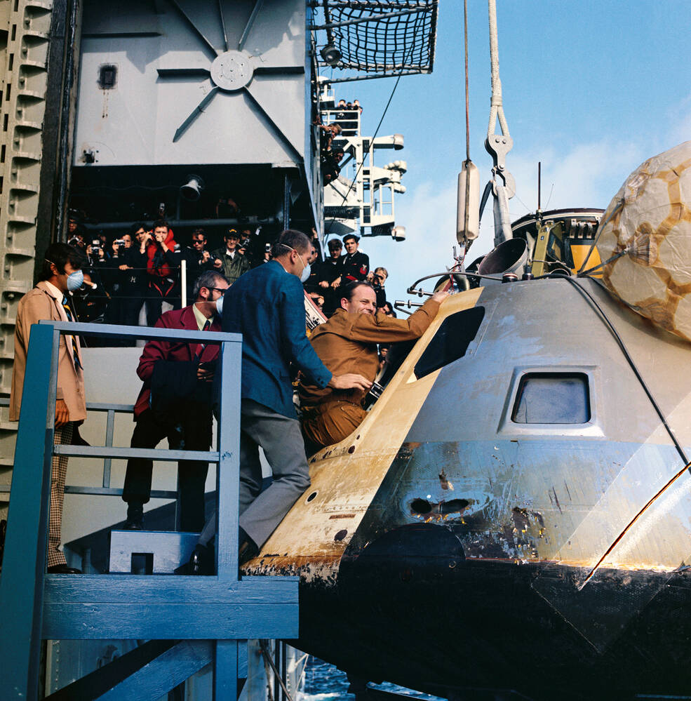 Recovery team members assist Skylab 3 astronaut Jack R. Lousma out of the CM on the deck of the USS New Orleans