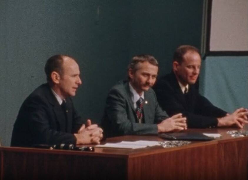 Bean makes a point during the press conference as Garriott and Lousma listen