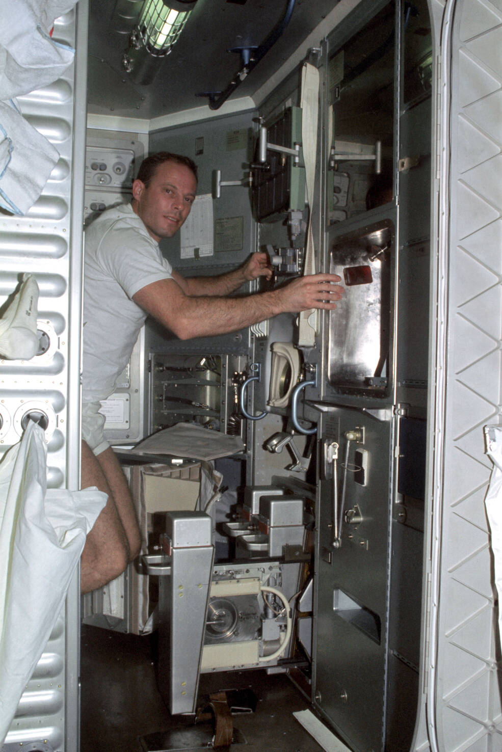 Skylab 3 astronaut Jack R. Lousma works at the Waste Collection System