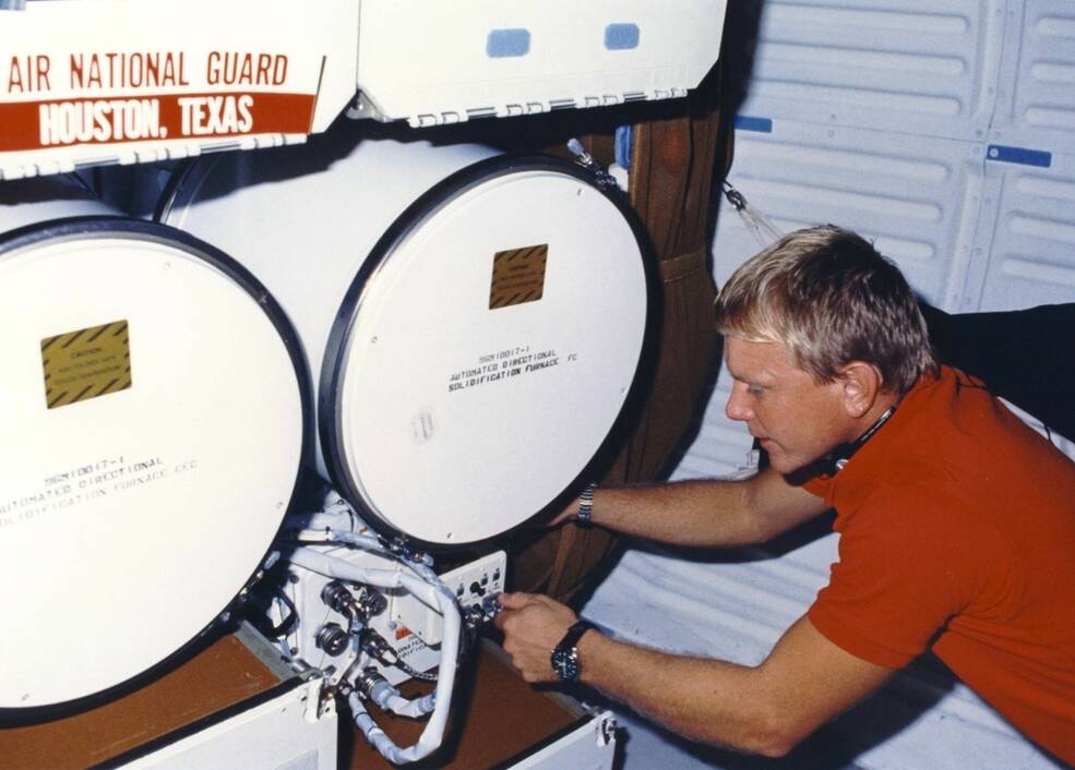 STS-26 astronaut George D. “Pinky” Nelson working on a secondary payload in Discovery’s middeck