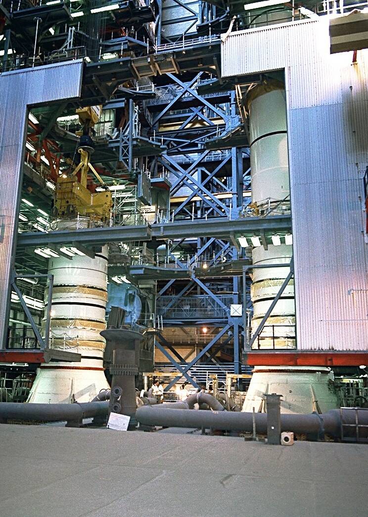 In KSC’s Vehicle Assembly Building (VAB), workers stack the segments of the Solid Rocket Boosters (SRBs). 