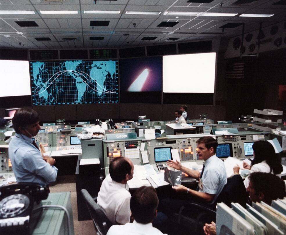 Controllers in Mission Control at NASA’s Johnson Space Center in Houston watch a replay of the STS-8 launch with Flight Director Jay H. Greene, and capsule communicators (capcoms) Guy S. Gardner and Bryan D. O’Connor