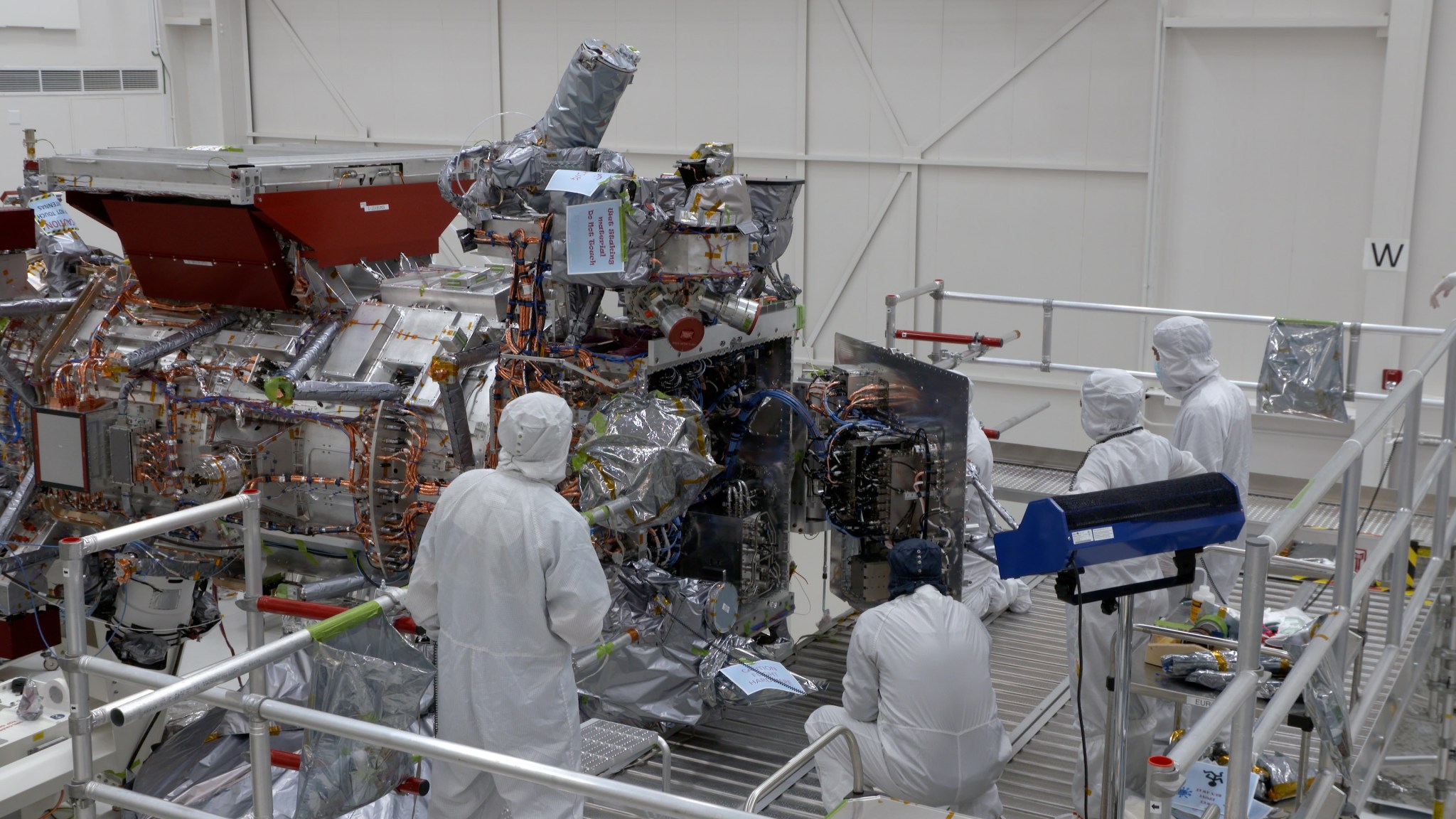 Engineers and technicians are seen closing the vault of NASA’s Europa Clipper in the main clean room of the Spacecraft Assembly Facility at JPL on Oct. 7. The vault will protect the electronics of the spacecraft as it orbits Jupiter.