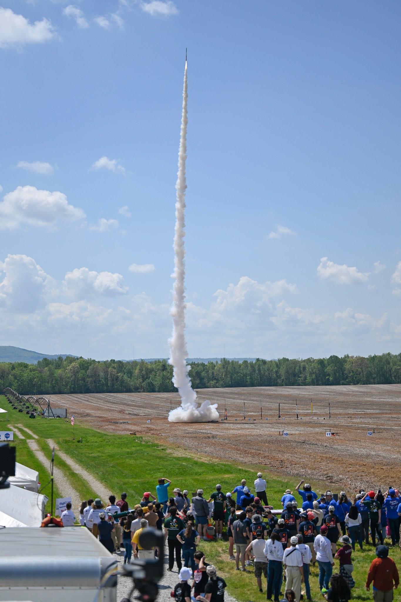 Student teams and attendees of NASA’s 2023 Student Launch competition observe a rocket take flight near NASA’s Marshall Space Flight Center in Huntsville, Alabama, April 2023.
