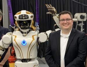 Evan Laske, deputy team lead for dexterous robots at NASA's Johnson Space Center, is pictured with the humanoid robot, Valkyrie. 