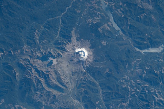iss070e006126 (Oct. 18, 2023) -- The active stratovolcano of Mount St. Helens in the state of Washington is blanketed with snow as the International Space Station orbited 260 miles above. To the top right of the image, the Swift Reservoir is visible, Yale Lake curving off below it.