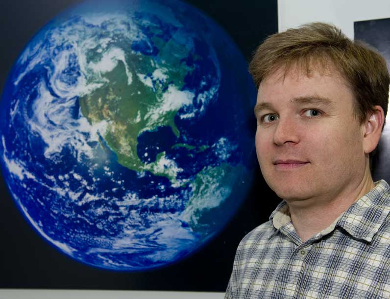 person standing in front of a large image of Earth
