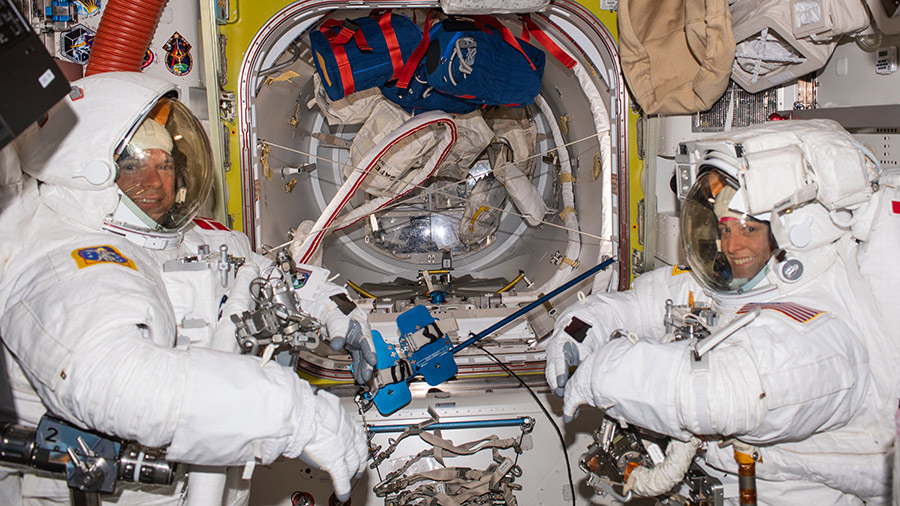 (From left) Astronauts Andreas Mogensen and Loral O'Hara try on their spacesuits and test the suits' components aboard the Quest airlock in preparation for their upcoming spacewalk.