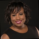 a black woman in a black dress on a black background