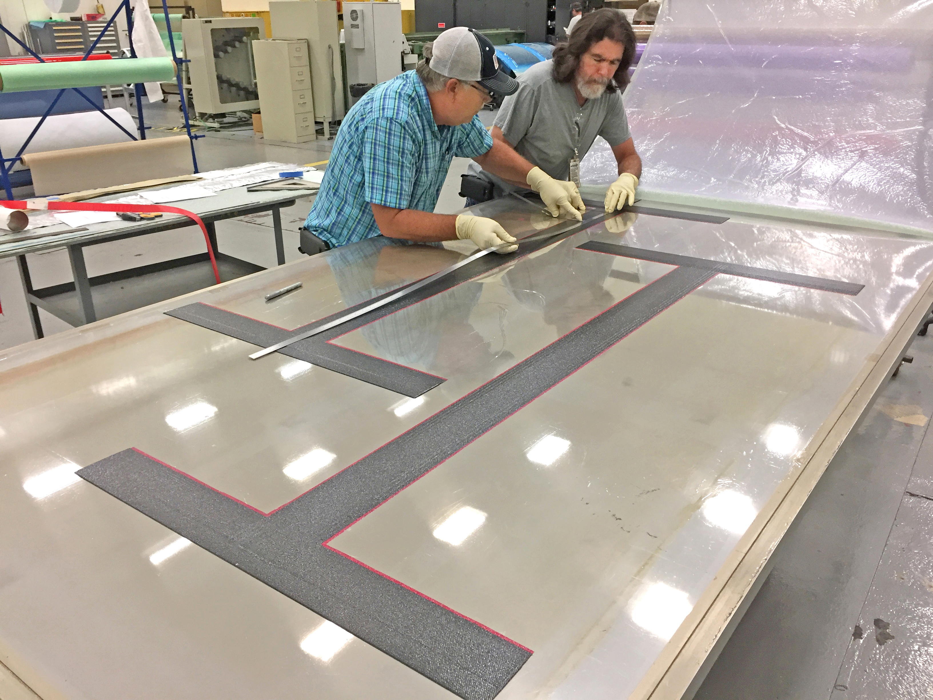 Composite Technologies for Exploration (CTE) team at NASA Marshall Space Flight Center lay up composite bonded joints on large-scale buckling panels.