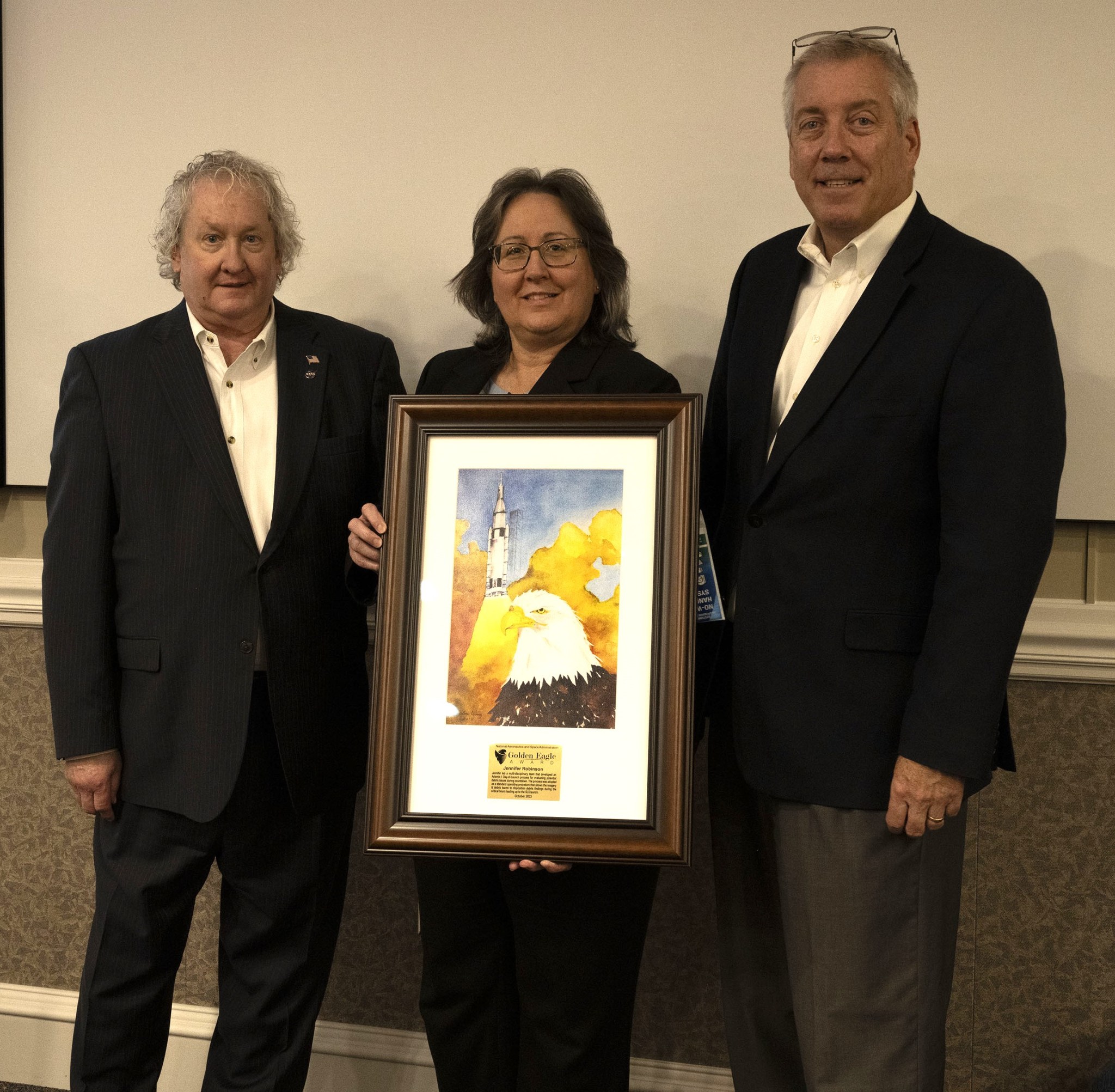 Golden Eagle Award winner Jennifer Robinson, center, receives a plaque commemorating her award during the Oct. 19 Mission Success is in Our Hands event. Joining Robinson are Bill Hill, left, director of the Safety and Mission Assurance Directorate at Marshall, and Jeff Haars, Jacobs vice president and program manager for Jacobs Space Exploration Group.