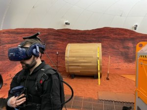 Months prior to CHAPEA Mission 1 start, Patrick Estep is pictured in the Martian sandbox testing and demonstrating some of the VR content that the crew would later take on themselves.