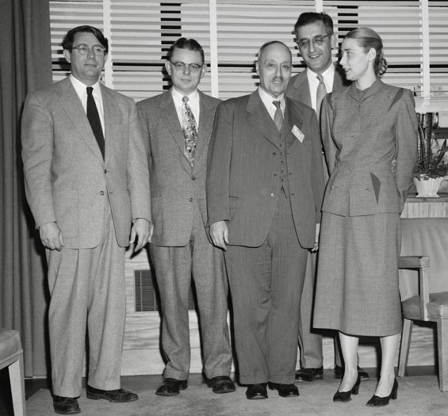 Four men and a woman standing in office.