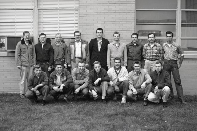 Group of young men posing outside building.