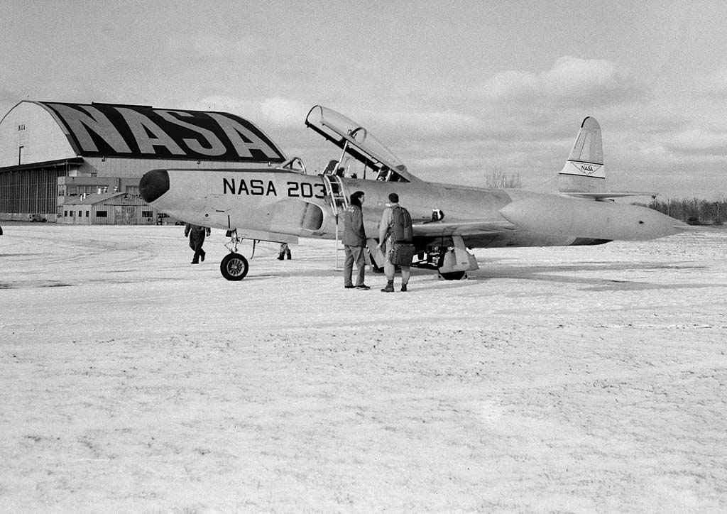 Crew standing next to airplane.
