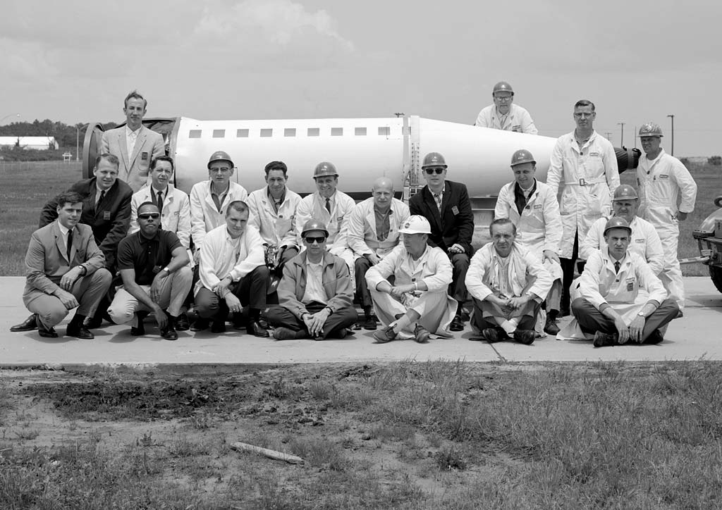 Group of men in front of sounding rocket.