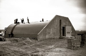 Workers on curved roof of concrete bunker.