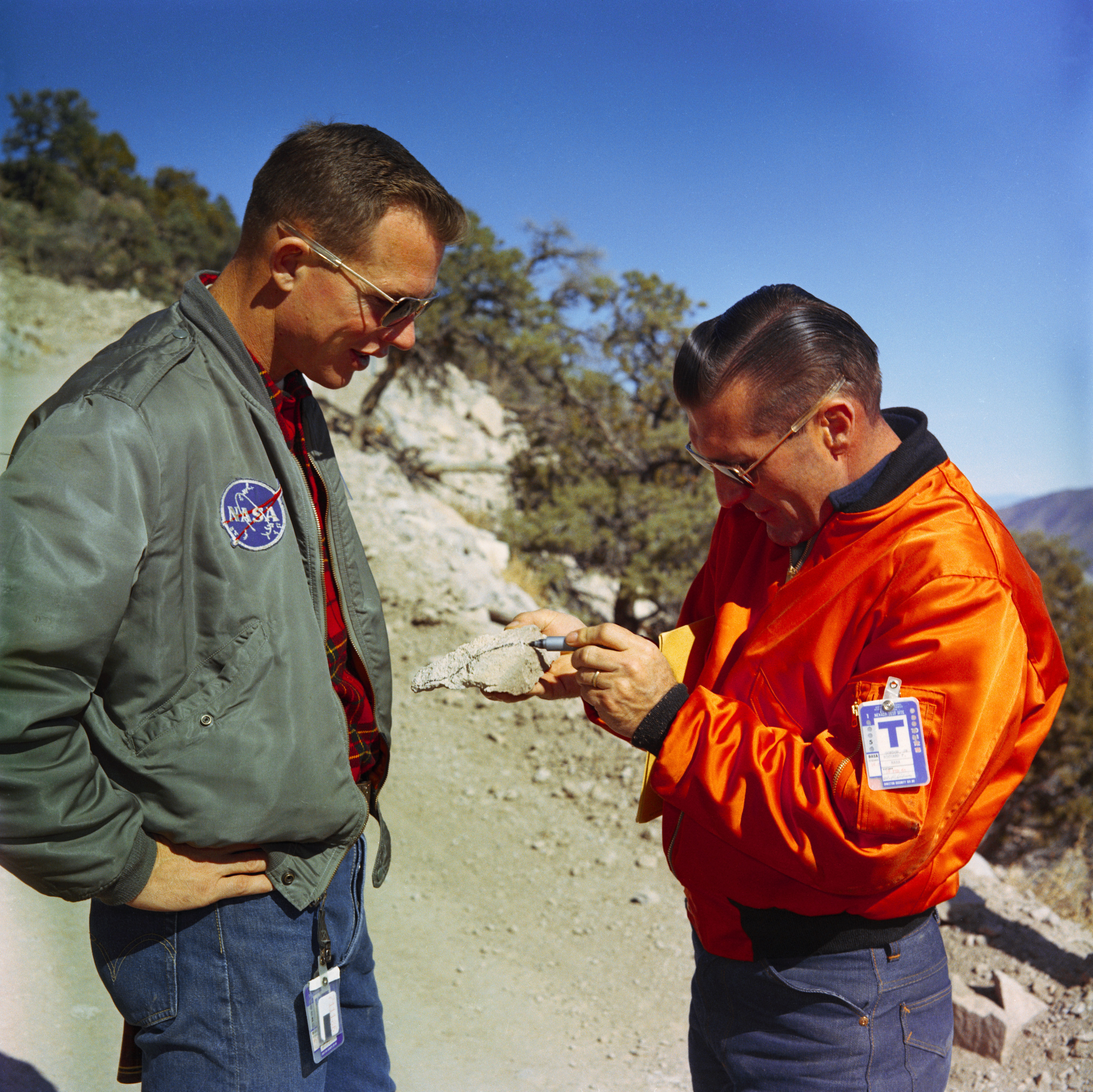 David R. Scott and Richard F. Gordon examine a rock sample during a geology field trip to the Nevada Test Site at Yucca Flats