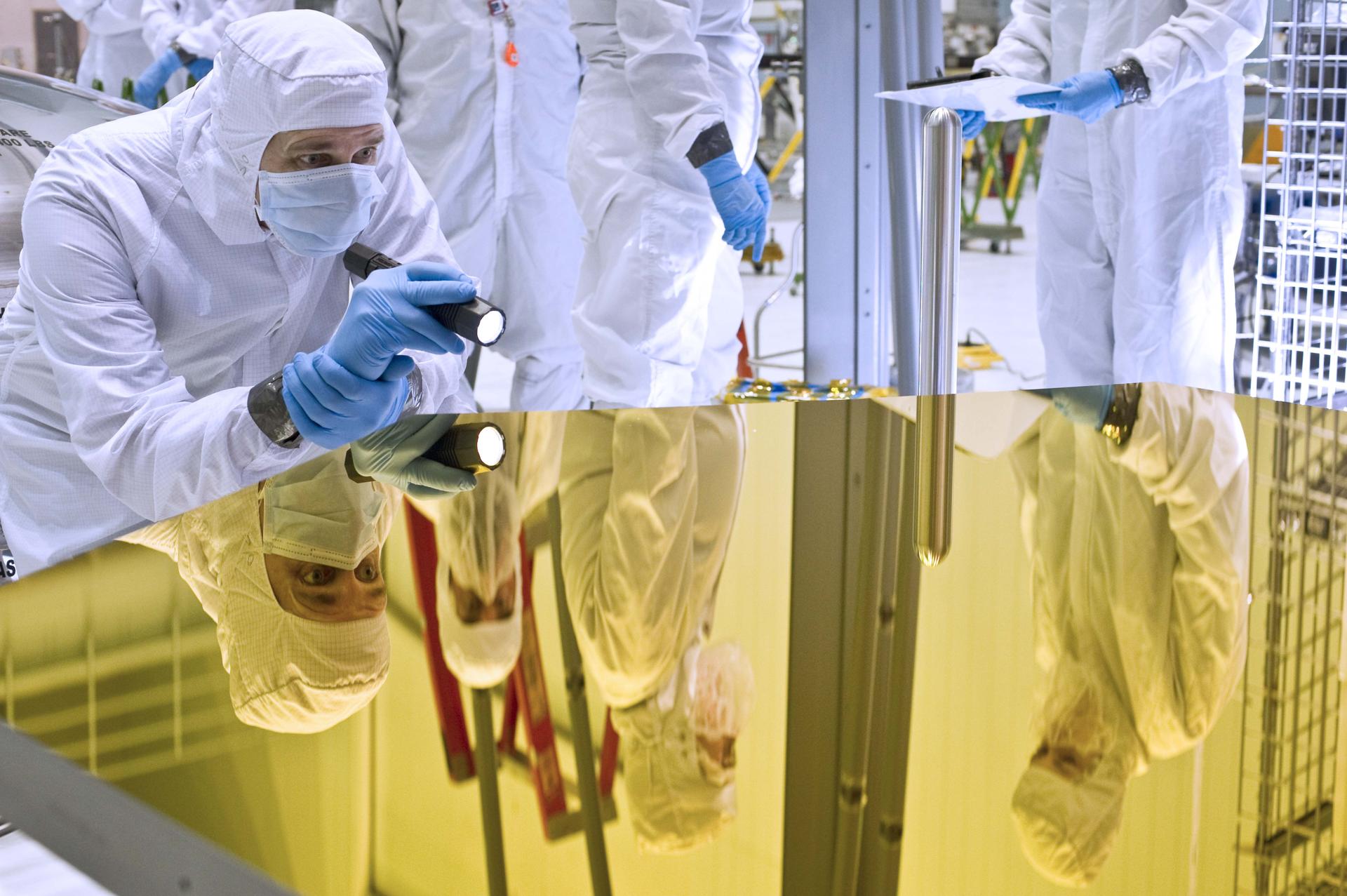 Engineer examining telescope mirror.