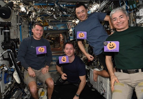 I 66 membri dell'equipaggio della missione: l'astronauta della NASA R.  Shane Kimbrough, a sinistra, e Thomas J.  Pesquet dell'Agenzia spaziale europea, Akihiko Hoshidi della Japan Aerospace Exploration Agency e l'astronauta della NASA Mark T.  Vandy sta mostrando le sue cartoline di Halloween.
