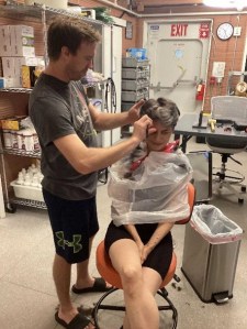 Science Officer Anca Selariu receives a haircut from Medical Officer Nathan Jones inside the CHAPEA habitat.