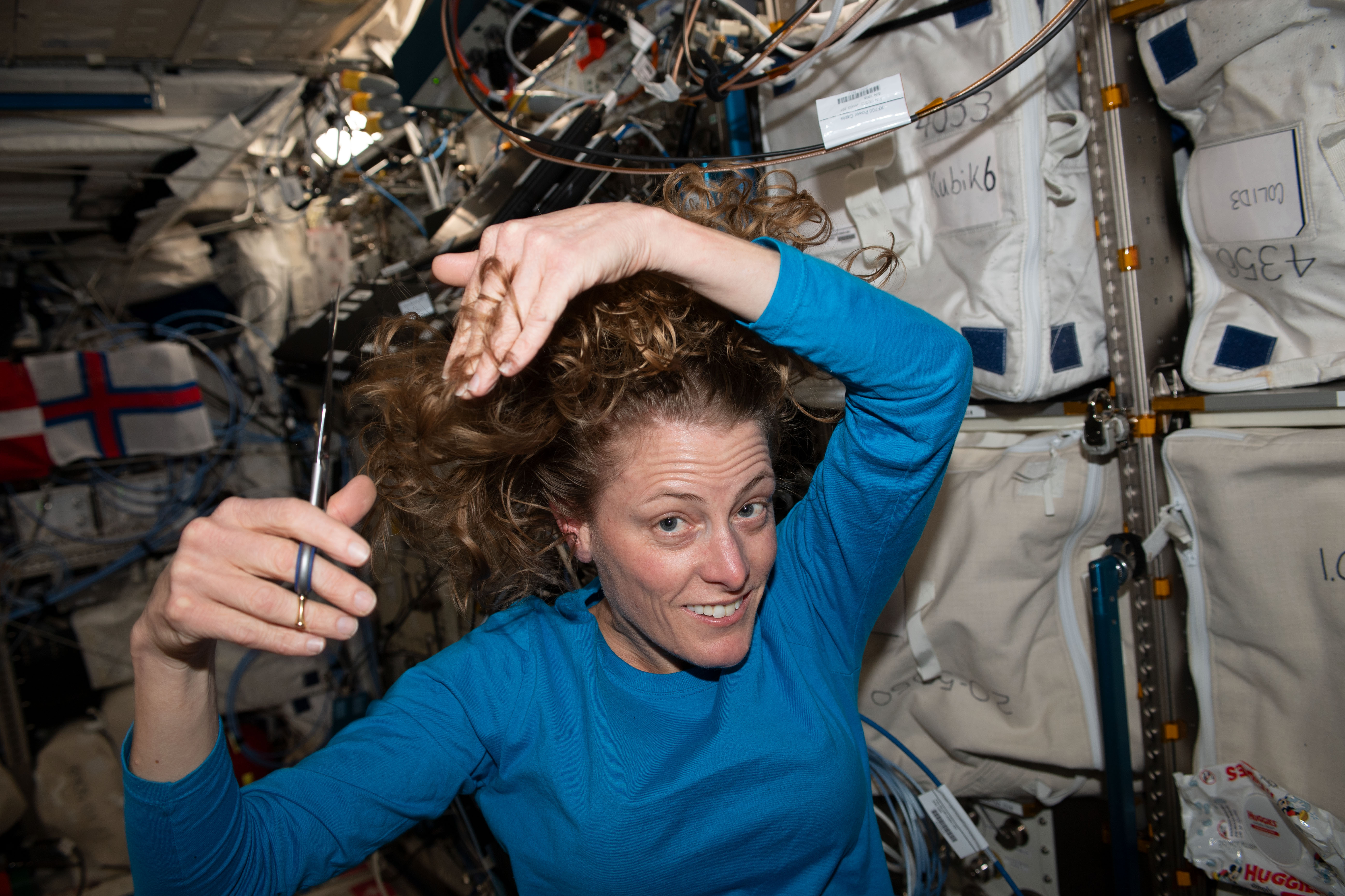 NASA astronaut and Expedition 70 Flight Engineer Loral O'Hara is pictured trimming her hair aboard the International Space Station.