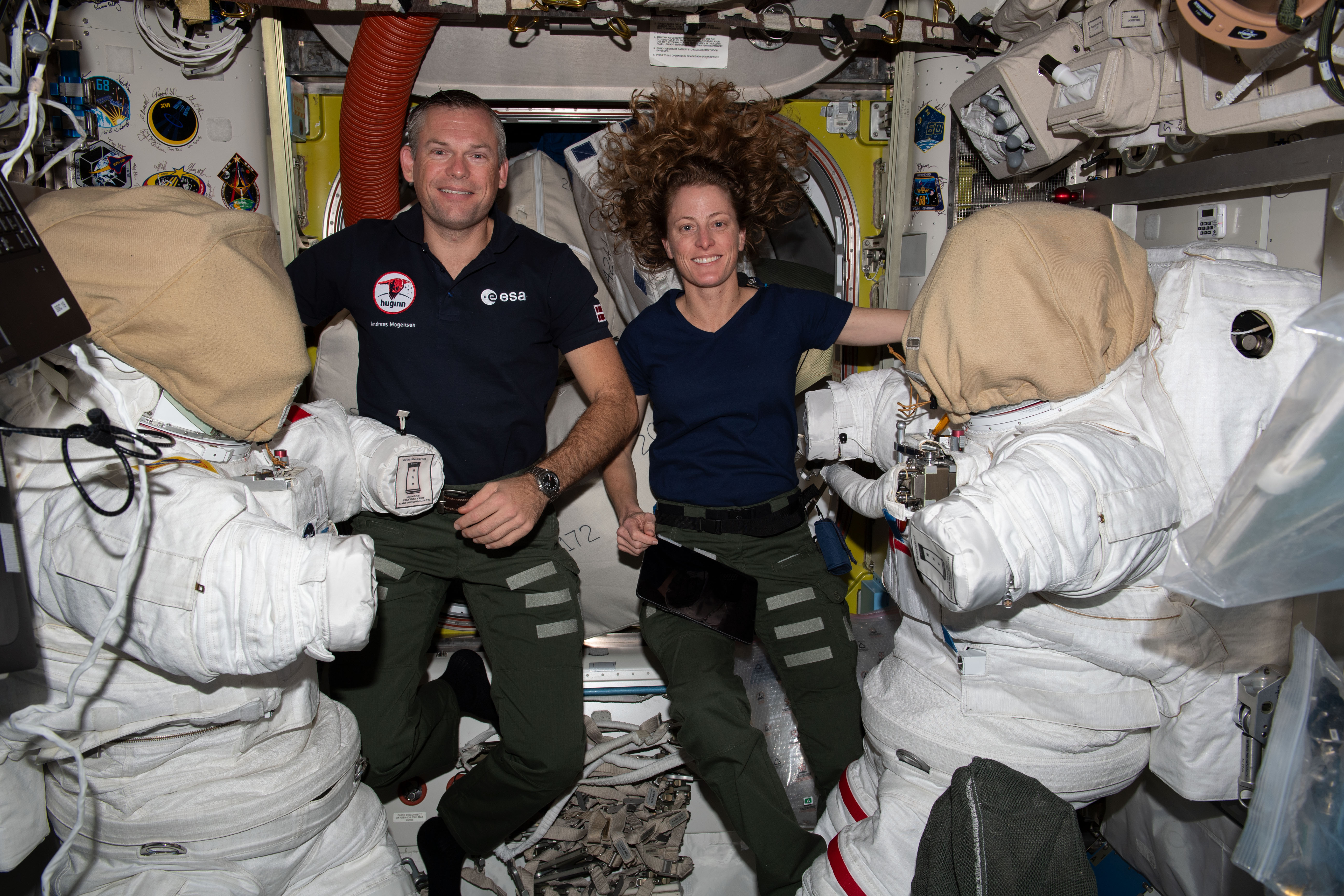 Astronauts Andreas Mogensen of ESA (European Space Agency) and Loral O'Hara of NASA service spacesuits inside the Quest airlock. The duo took turns cleaning cooling loops inside the suits ahead of a spacewalk planned for Oct. 12 to collect microbe samples from specific areas outside of the International Space Station. Scientists want to analyze the types of microbes that may be able to survive the harsh environment of outer space.