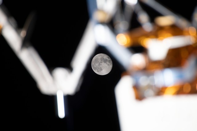 September's full Moon, the Harvest Moon, is photographed from the International Space Station, perfectly placed in between exterior station hardware
