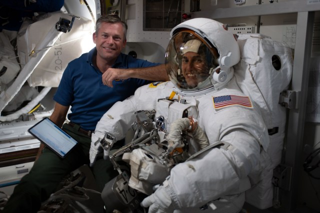 Expedition 70 Commander Andreas Mogensen from ESA (European Space Agency) assists NASA astronaut Jasmin Moghbeli as she tries on her spacesuit and tests its components aboard the International Space Station's Quest airlock in preparation for an upcoming spacewalk.
