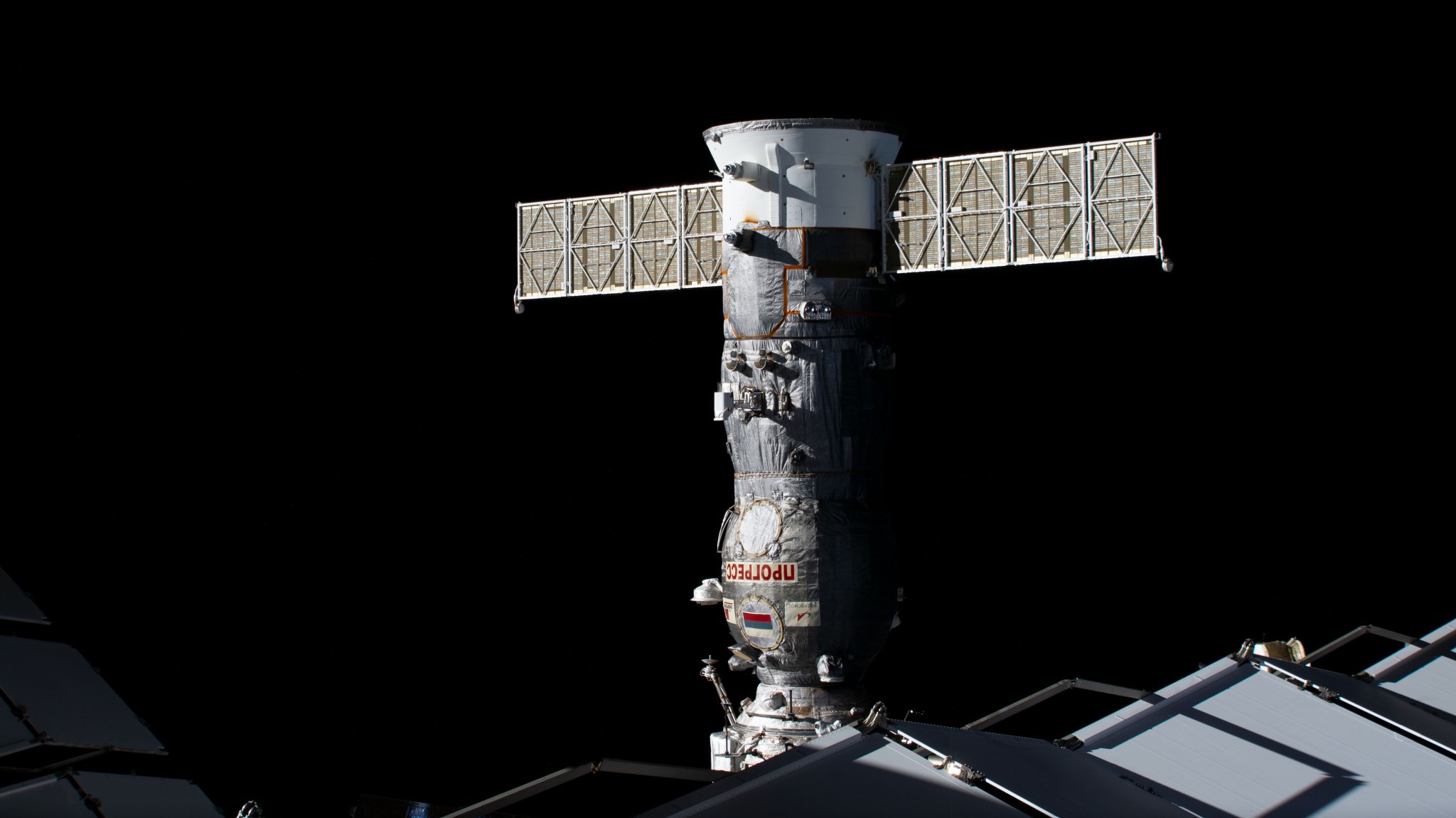 The Roscosmos Progress 84 cargo craft is pictured docked to the International Space Station's Poisk module.