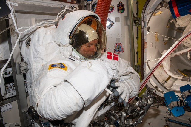 ESA (European Space Agency) astronaut and Expedition 70 Commander Andreas Mogensen is pictured trying on his spacesuit and testing its components aboard the International Space Station's Quest airlock in preparation for an upcoming spacewalk.