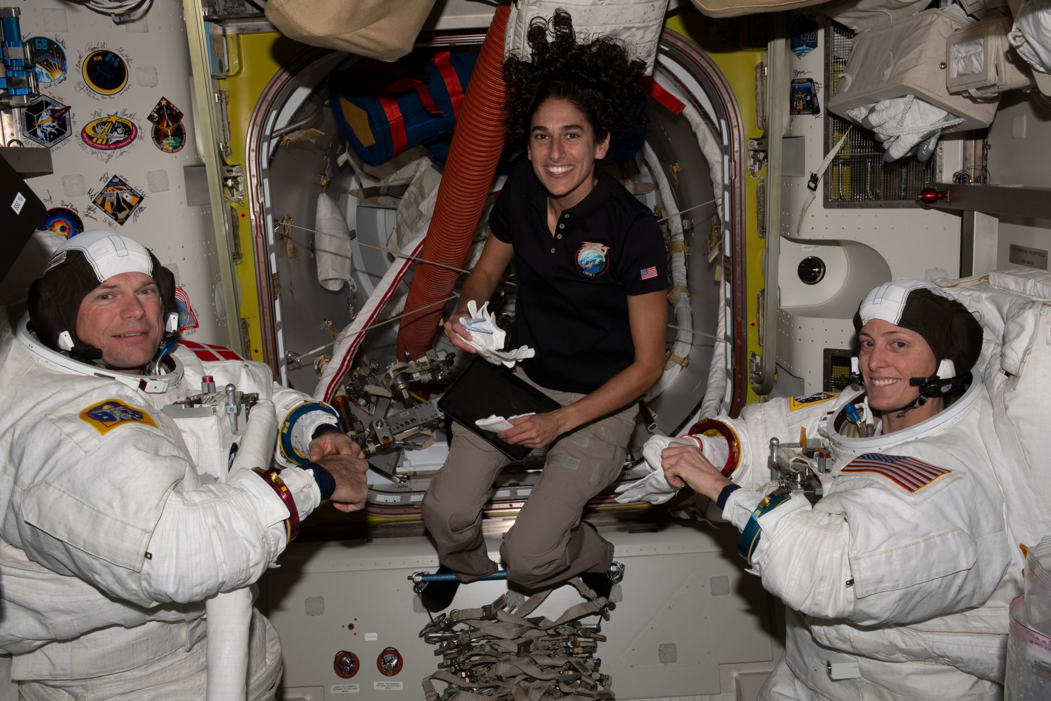 NASA astronaut Jasmin Moghbeli (center) assists astronauts Andreas Mogensen (left) from ESA (European Space Agency) and Loral O'Hara (right) from NASA as they try on their spacesuits and test the suits' components aboard the International Space Station's Quest airlock in preparation for an upcoming spacewalk.