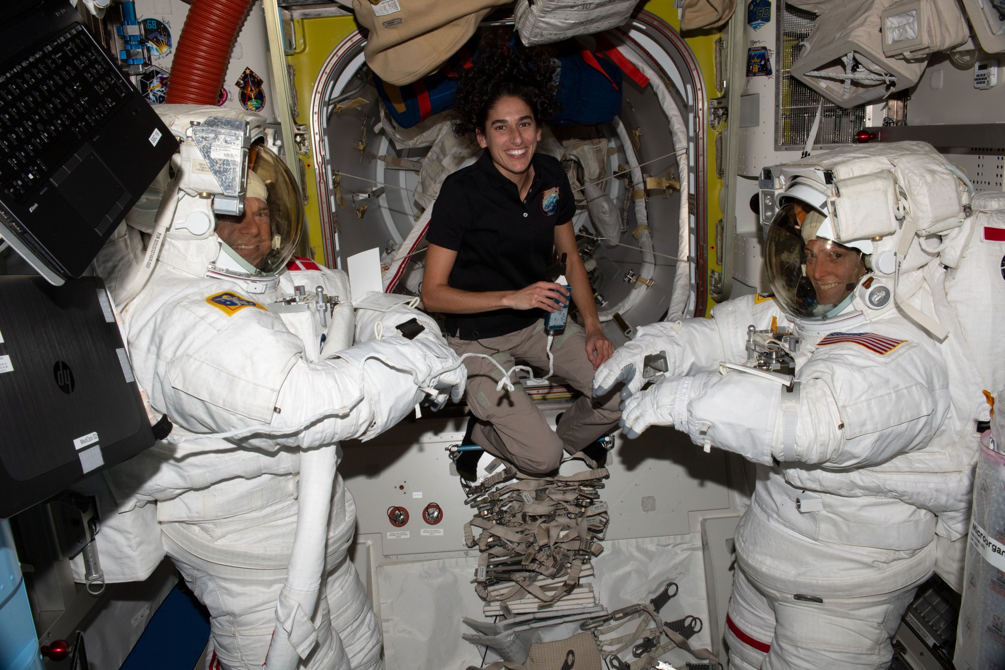 NASA astronaut Jasmin Moghbeli (center) assists astronauts Andreas Mogensen (left) from ESA (European Space Agency) and Loral O'Hara (right) from NASA as they try on their spacesuits and test the suits' components aboard the International Space Station's Quest airlock in preparation for an upcoming spacewalk.