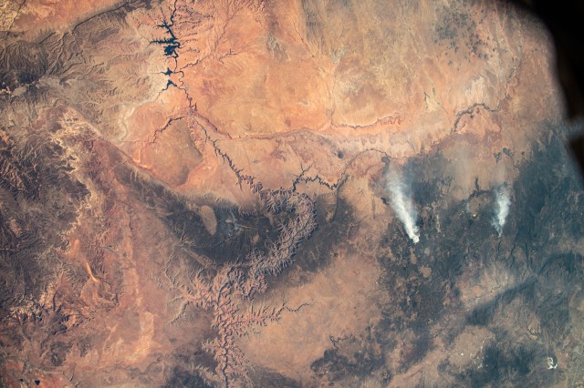 A pair of wildfires near Flagstaff, Arizona, are pictured from the International Space Station as it orbited 261 miles above Lake Powell (top left) and the Grand Canyon (center).